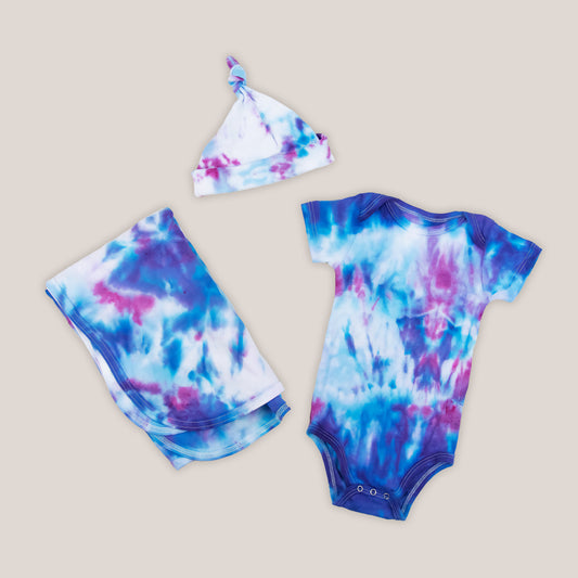 Blue and pink tie dye organic baby bodysuit, baby hat, and blanket set.