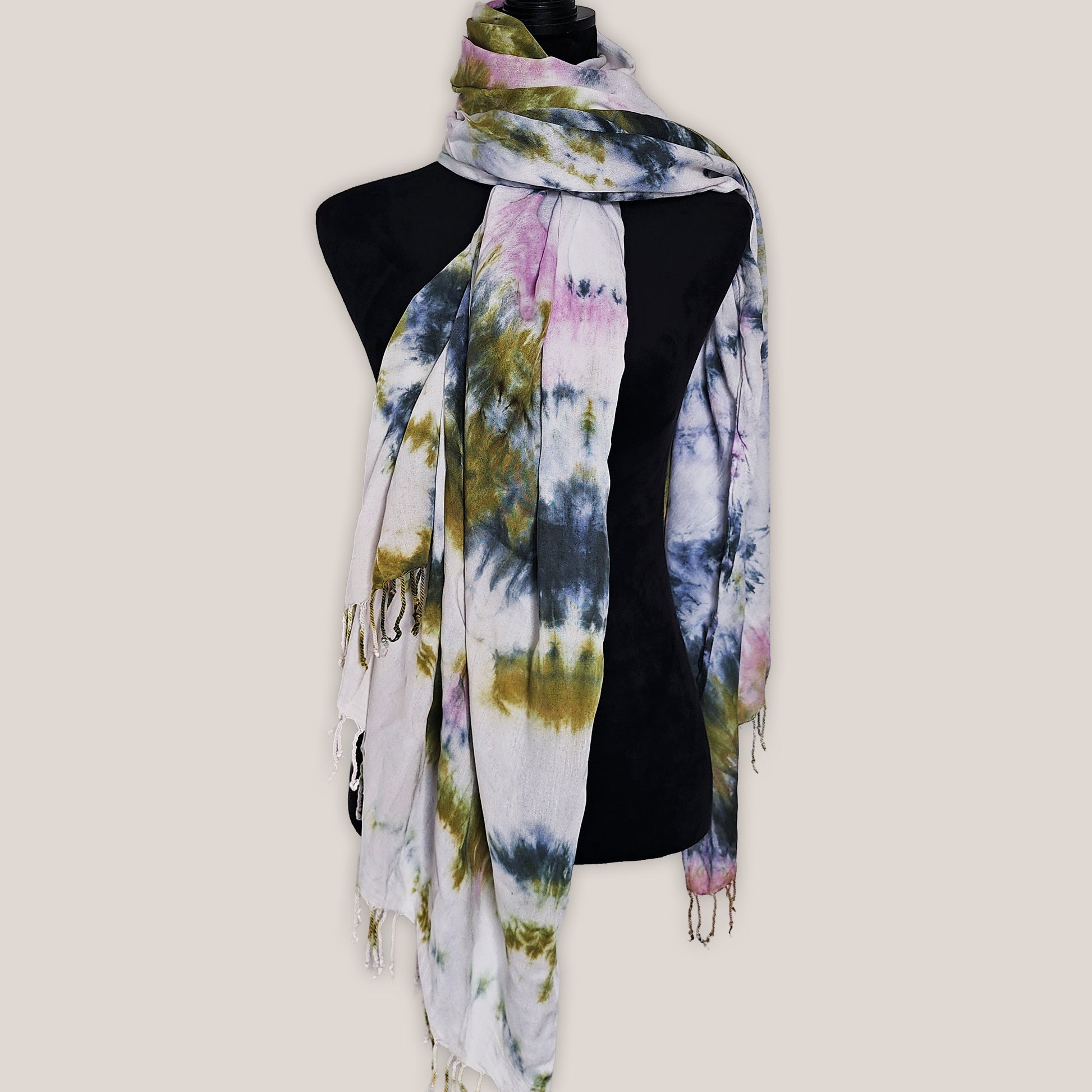 Colorful tie-dye scarf on a mannequin against a plain background