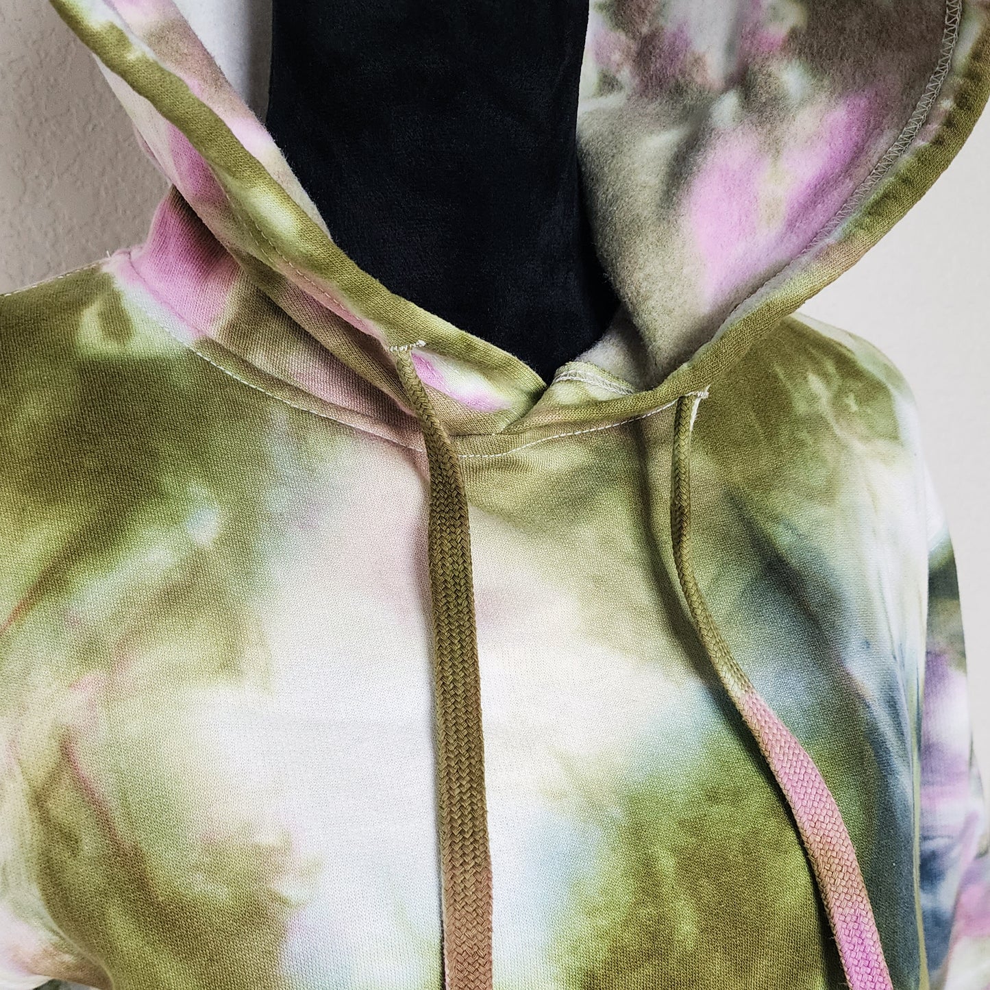 Close-up of a tie-dye hoodie with a colorful pattern.