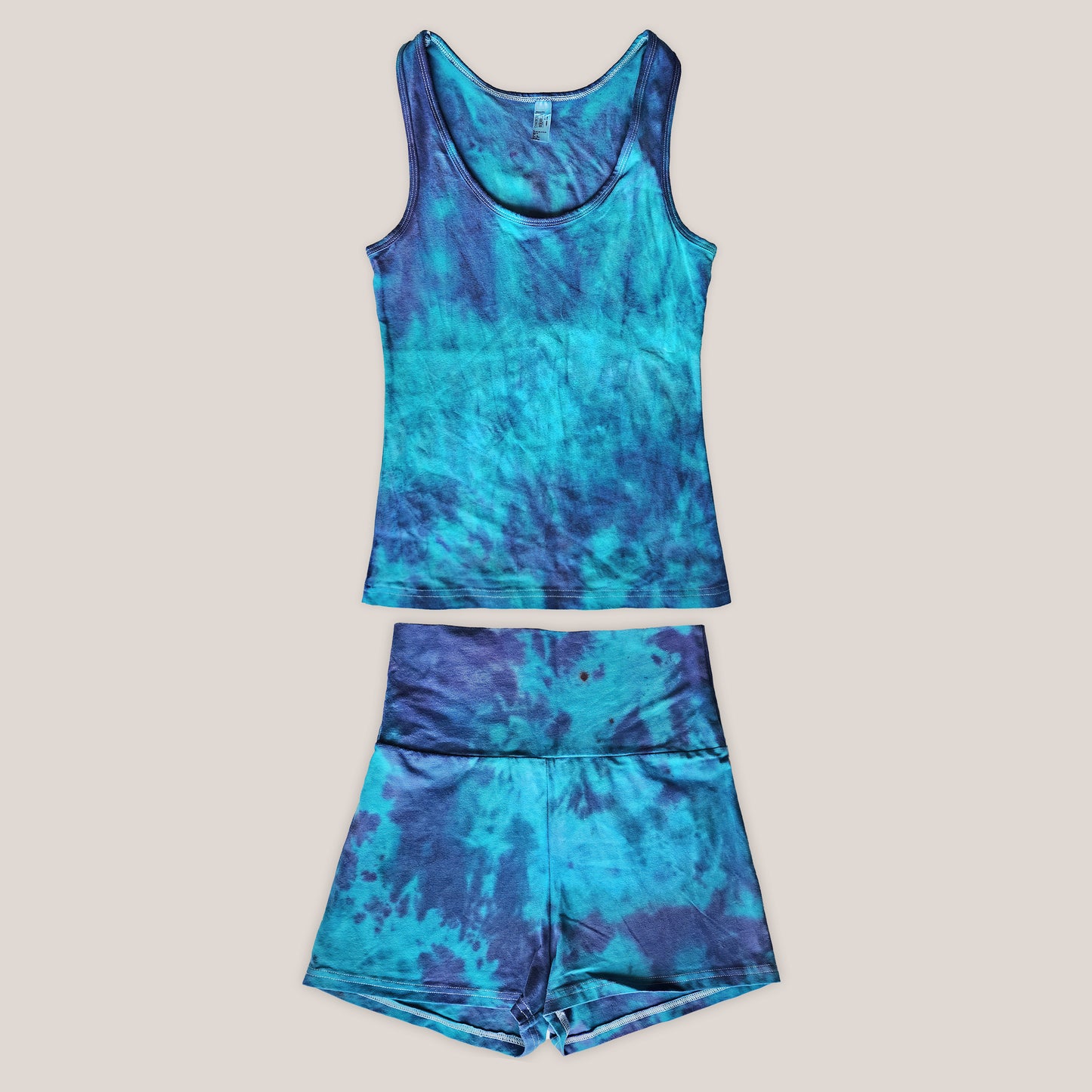 Blue tie-dye tank top and shorts set on a beige background
