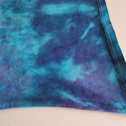 Blue and purple tie-dye fabric on a beige background
