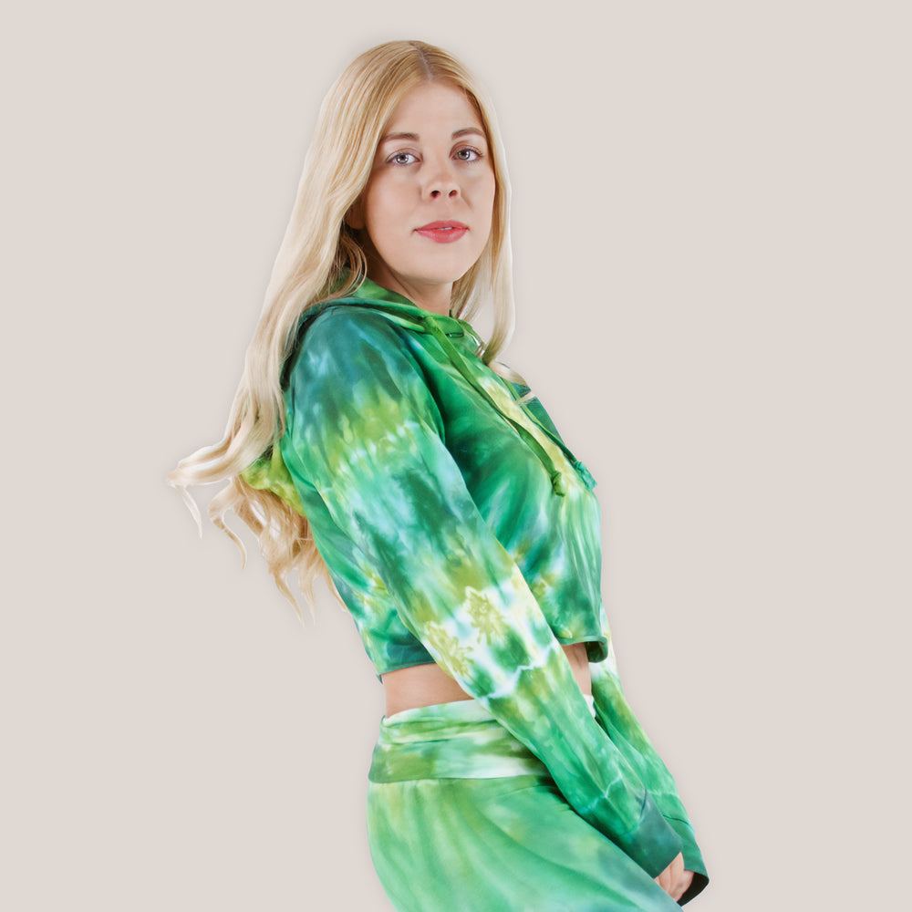 Woman wearing an Akasha Sun green tie dye crop top with a hood.