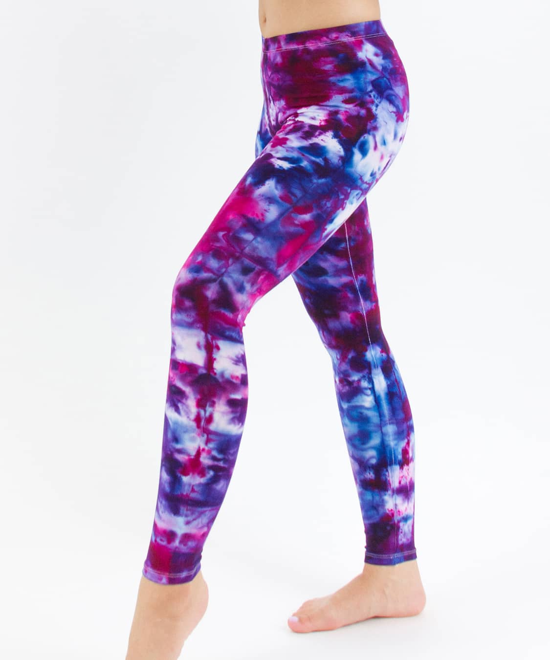 Woman wearing a pair of pink and blue tie dye leggings created with ice dye techniques.