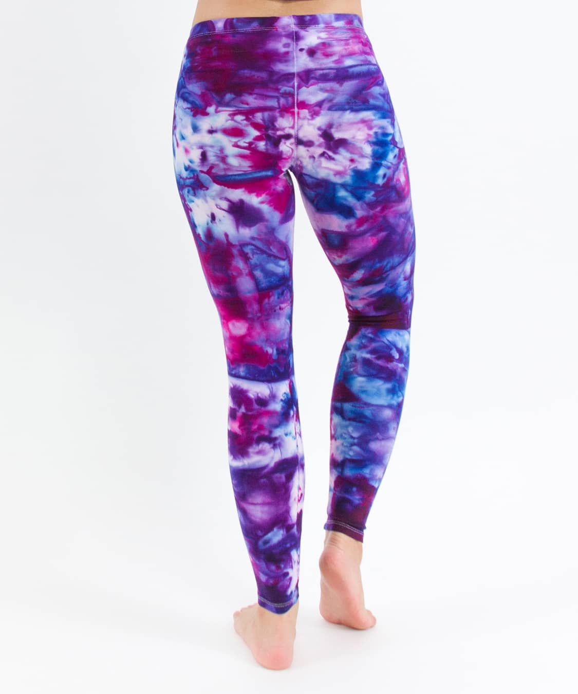 Woman wearing a pair of pink and blue tie dye leggings created with ice dye techniques.