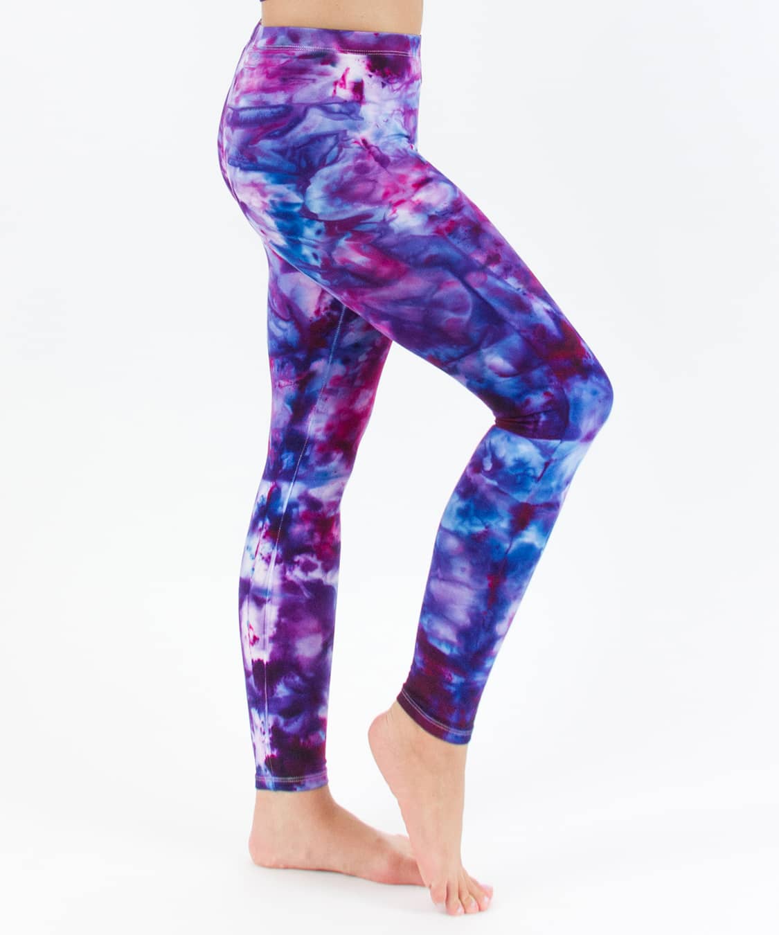 Woman wearing a pair of pink and blue tie dye leggings created with ice dye techniques.