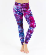 Woman wearing a pair of pink and blue tie dye leggings created with ice dye techniques.