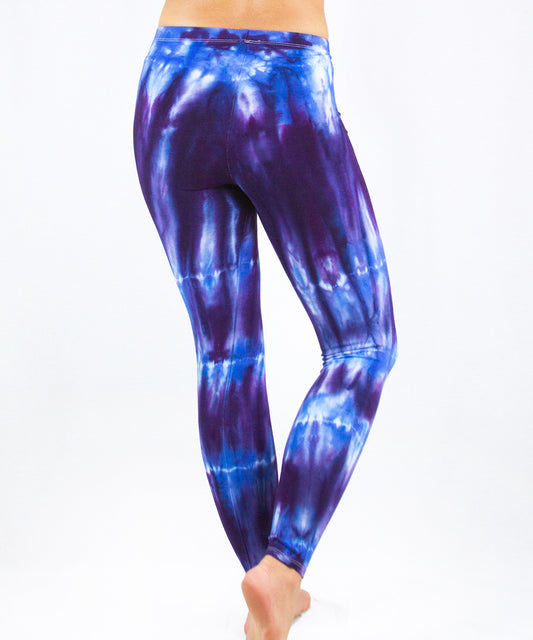 Woman wearing a pair of blue and purple tie dye leggings made of sustainable cotton.