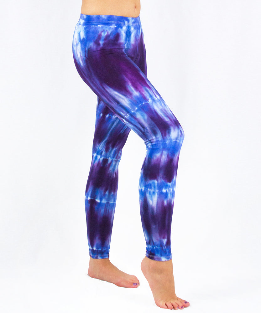 Woman wearing a pair of blue and purple tie dye leggings made of sustainable cotton.