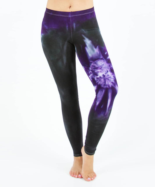 Woman wearing a pair of Akasha Sun purple chakra tie dye leggings made of sustainable cotton.