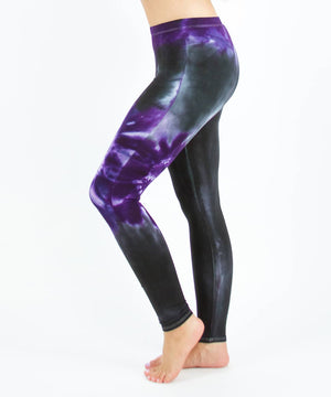 
                
                    Load image into Gallery viewer, Woman wearing a pair of Akasha Sun purple chakra tie dye leggings made of sustainable cotton.
                
            