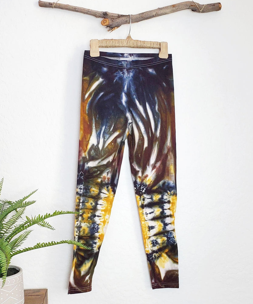 
                
                    Load image into Gallery viewer, A pair of tie dye leggings in amber, black, and yellow.
                
            
