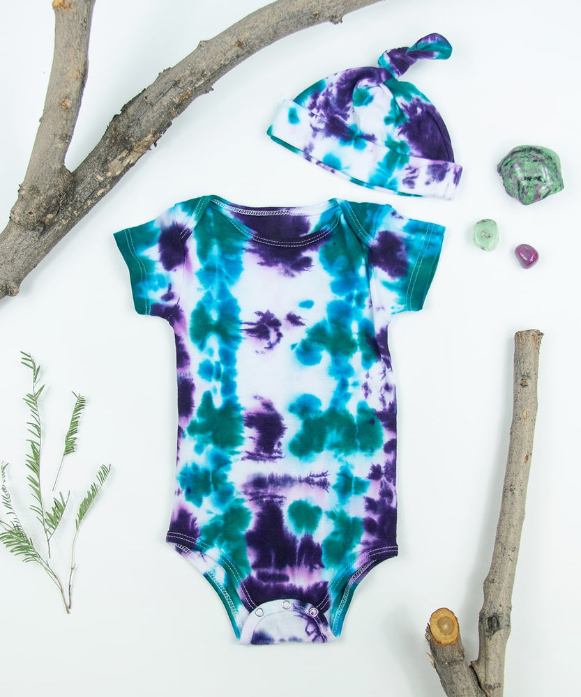 
                
                    Load image into Gallery viewer, Teal + Purple tie dye baby bodysuit + hat set made of organic cotton.
                
            
