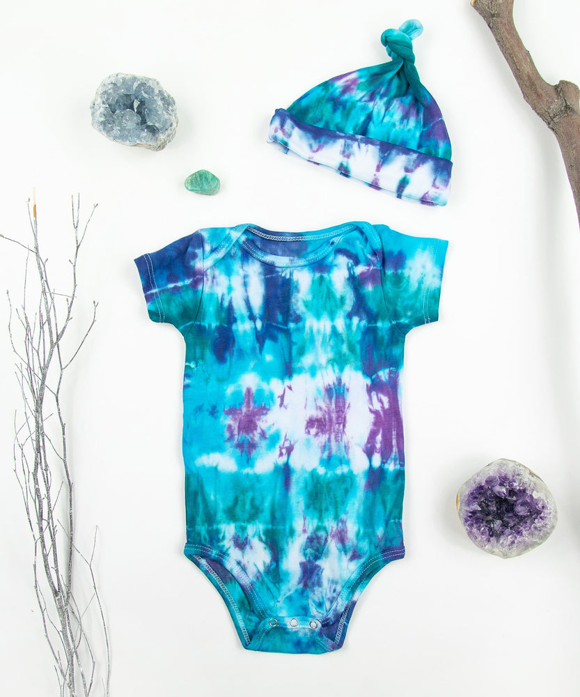 Blue, teal, and purple tie dye baby onesie and hat by Akasha Sun.