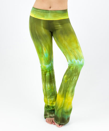 Woman wearing a pair of green tie dye yoga pants with a fold over waistband by Akasha Sun.