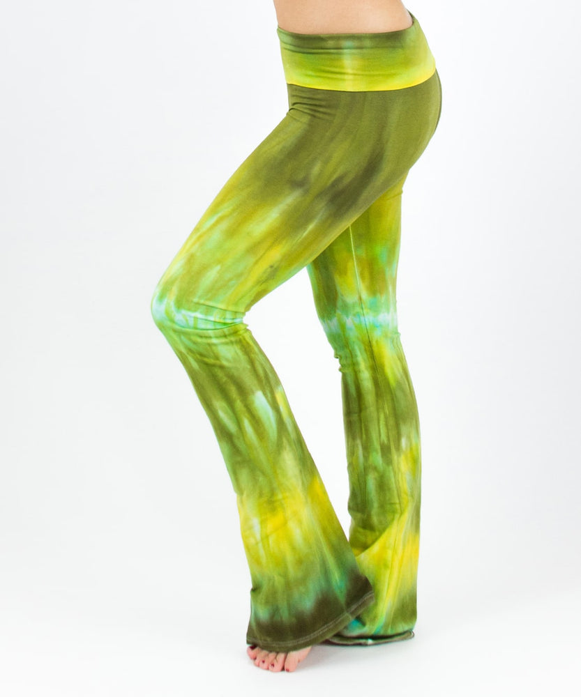 Woman wearing a pair of green tie dye yoga pants with a fold over waistband by Akasha Sun.