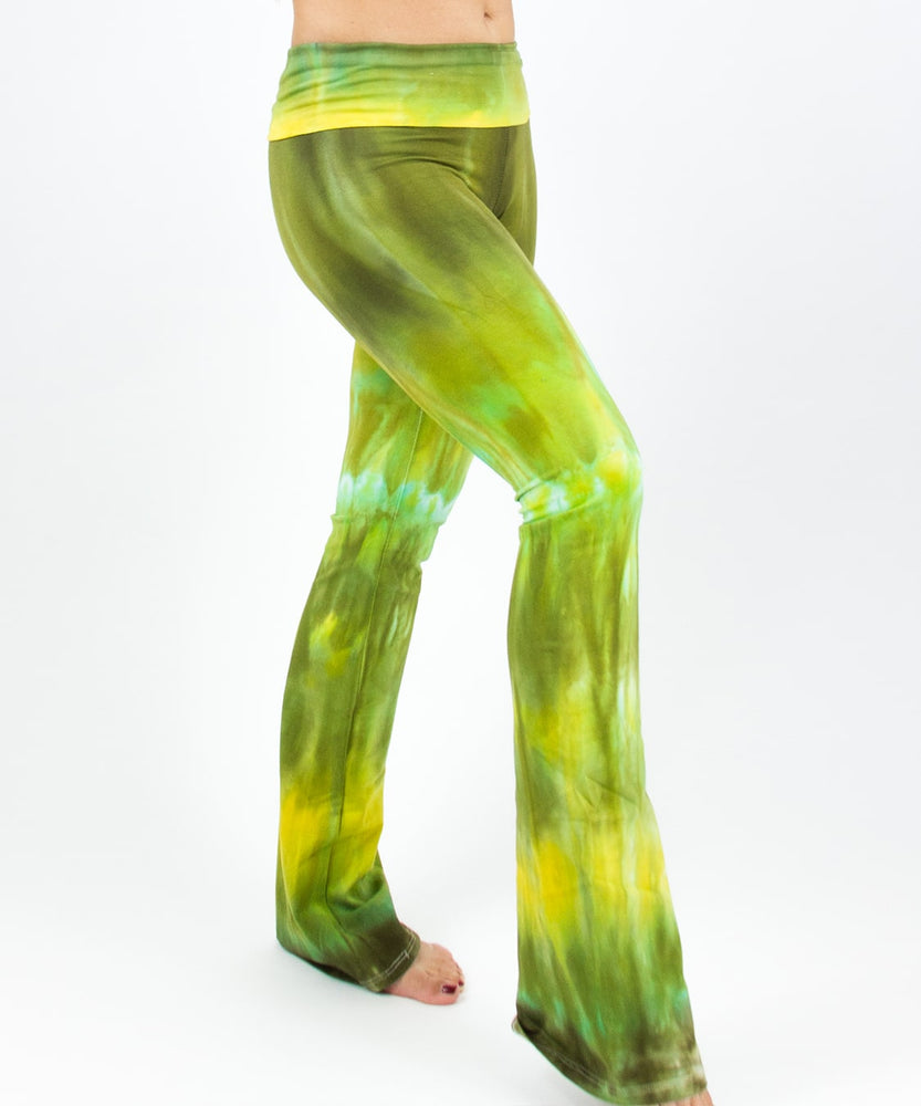 Woman wearing a pair of green tie dye yoga pants with a fold over waistband by Akasha Sun.