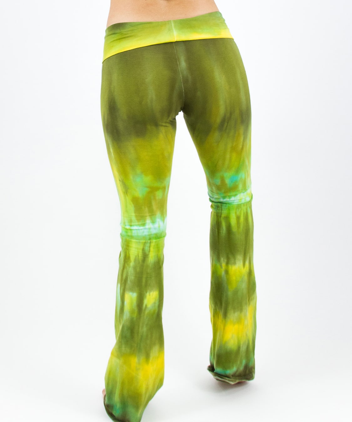 Woman wearing a pair of green tie dye yoga pants with a fold over waistband by Akasha Sun.