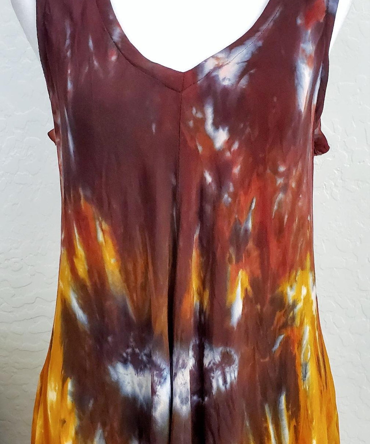 An amber and black tie dye short sleeve waterfall dress with a v-neck.