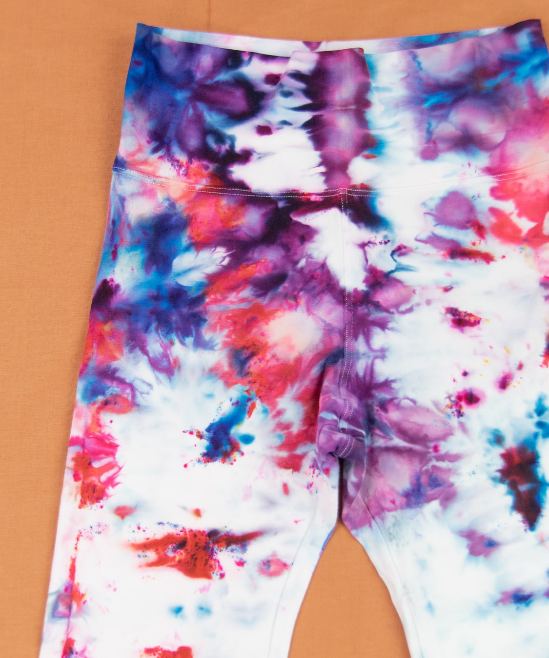 Ice dyed yoga pants in the colors purple, red, and blue.