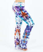 Woman wearing a pair of rainbow tie dye yoga pants that have been ice dyed.