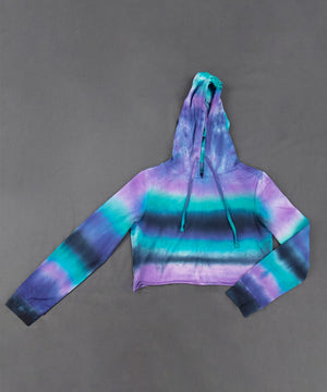 Purple, teal, and black tie dye hoodie crop top with a hood, drawstring, and long sleeves.