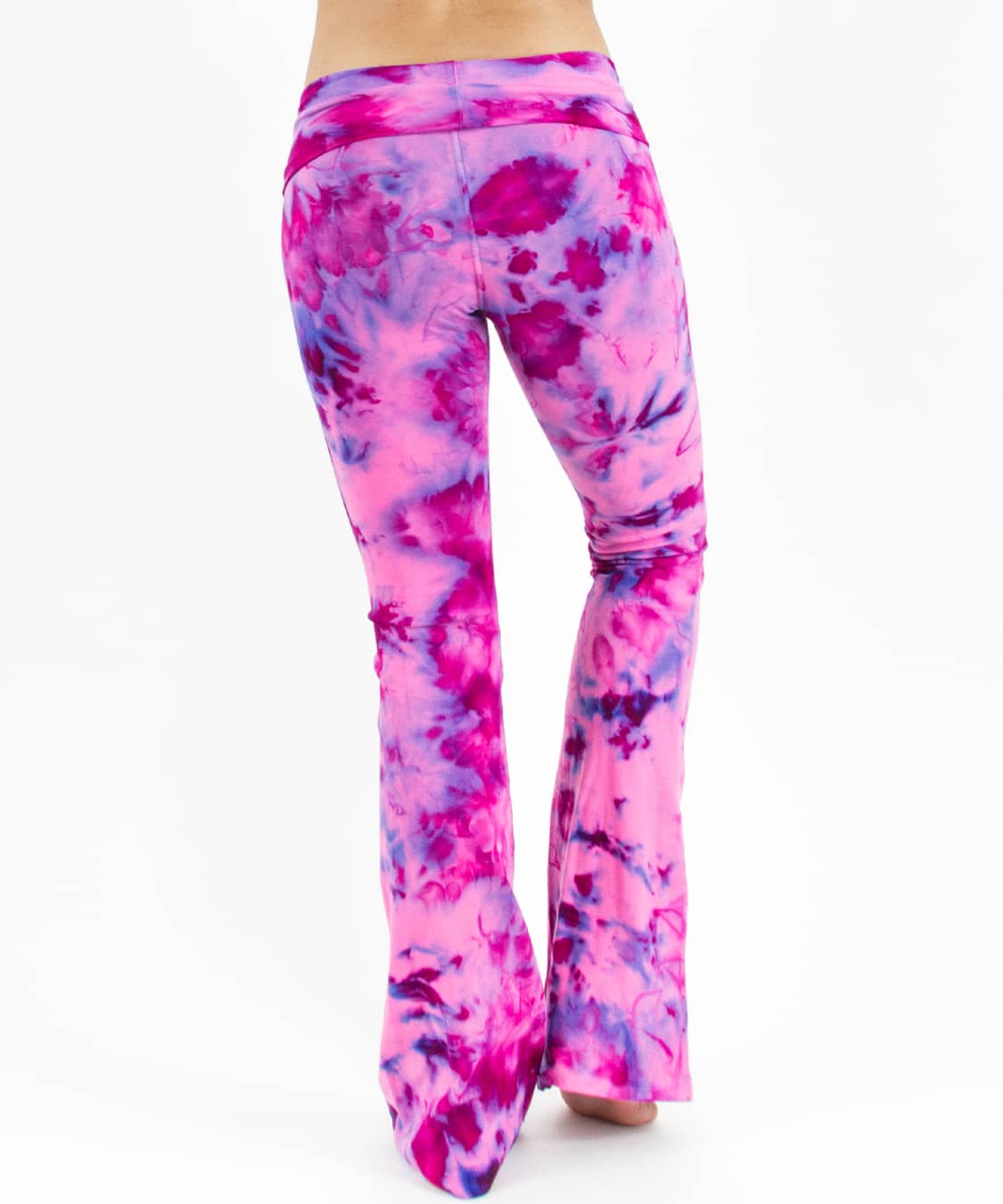 Woman wearing a pair of fold over tie dye yoga pants in the colors pink and purple.