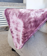A dusty rose pink organic tie dye baby blanket.