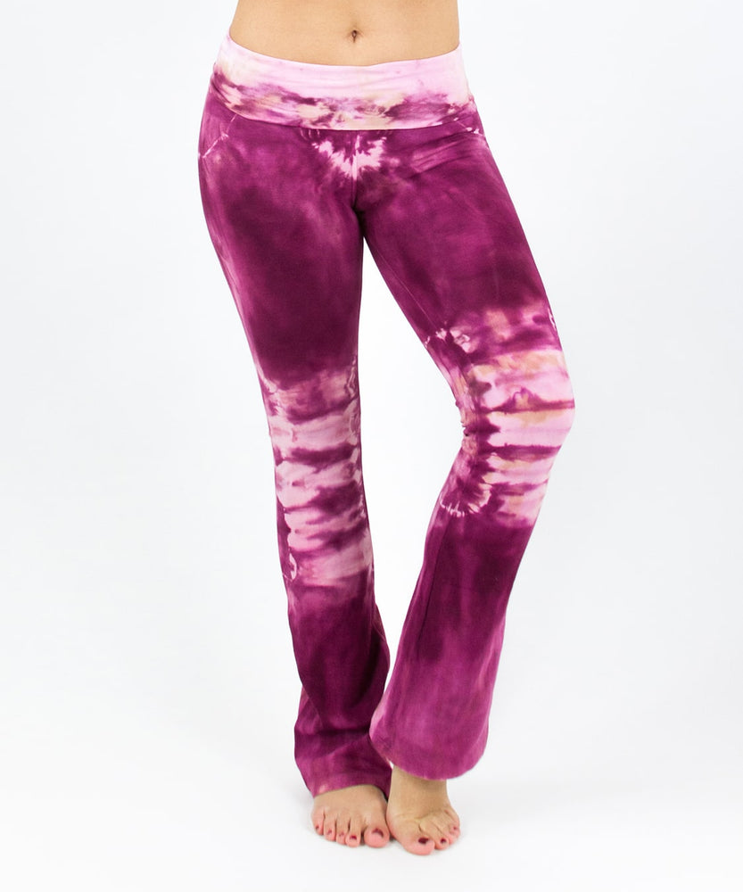 Woman wearing a pair of tie dye pink yoga pants featuring a fold over waistband by Akasha Sun.