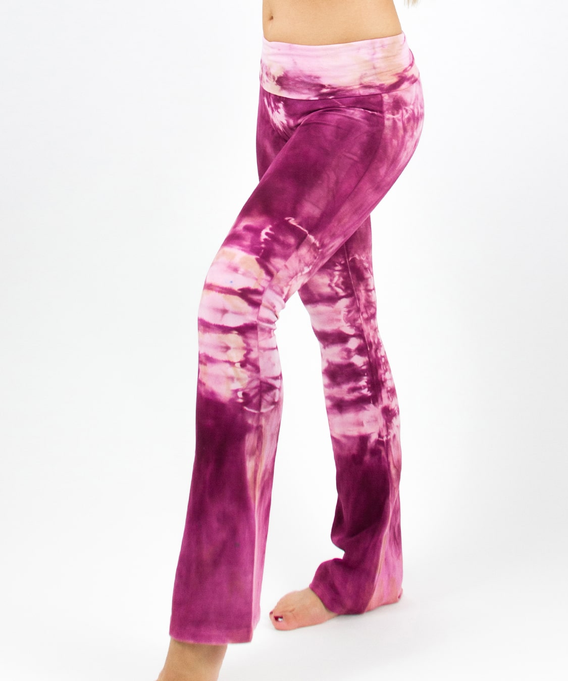 Woman wearing a pair of tie dye pink yoga pants featuring a fold over waistband by Akasha Sun.