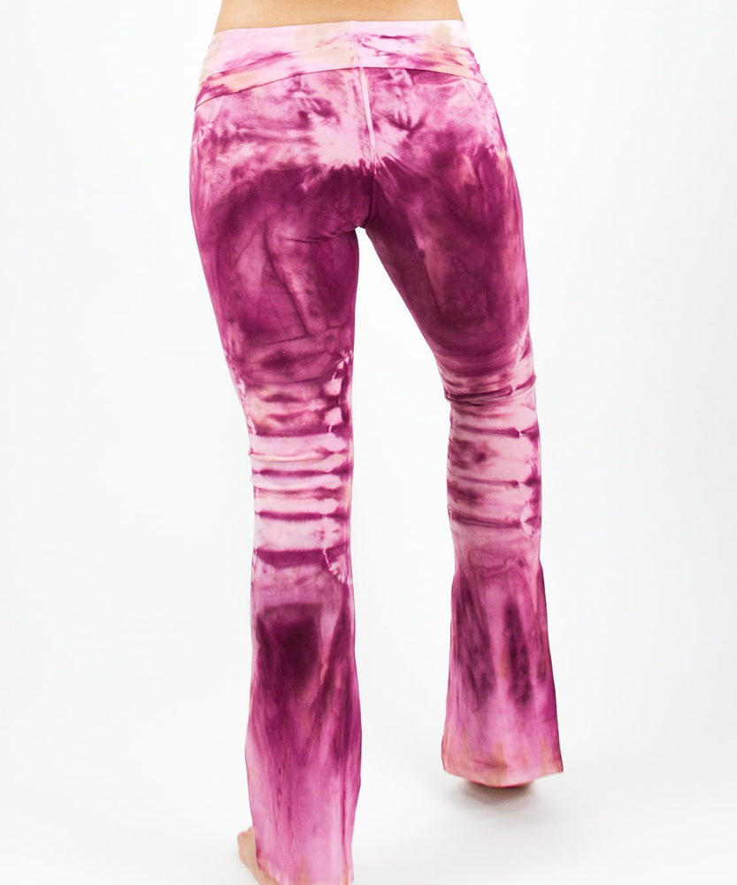 Woman wearing a pair of tie dye pink yoga pants featuring a fold over waistband by Akasha Sun.
