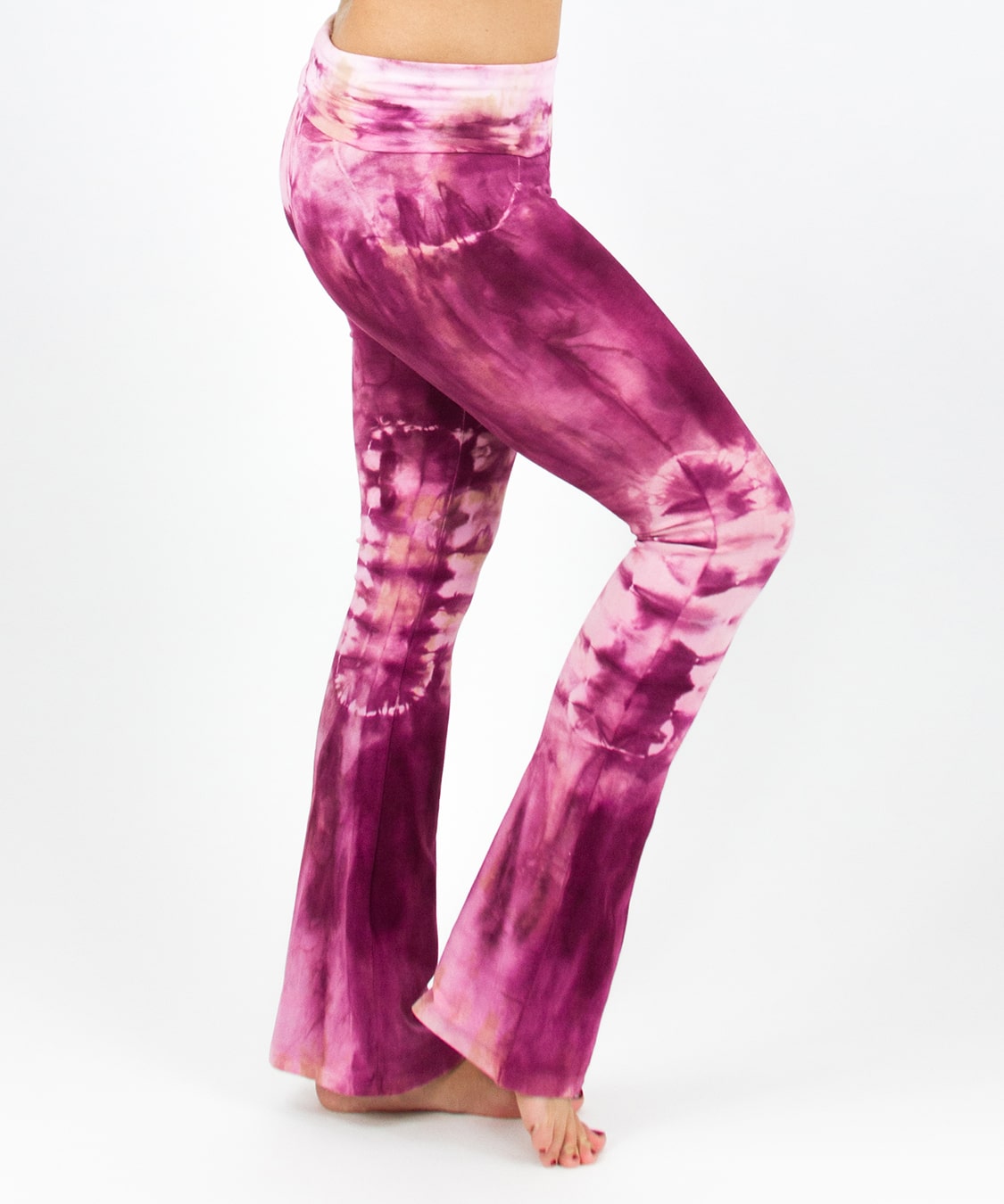 Woman wearing a pair of tie dye pink yoga pants featuring a fold over waistband by Akasha Sun.