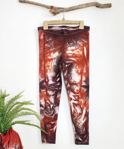 A burnt orange and brown tie dye pair of yoga leggings.