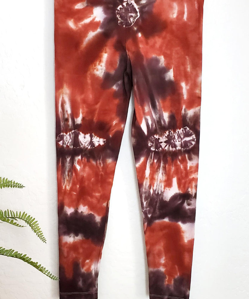 
                
                    Load image into Gallery viewer, A burnt orange and brown tie dye pair of yoga leggings.
                
            