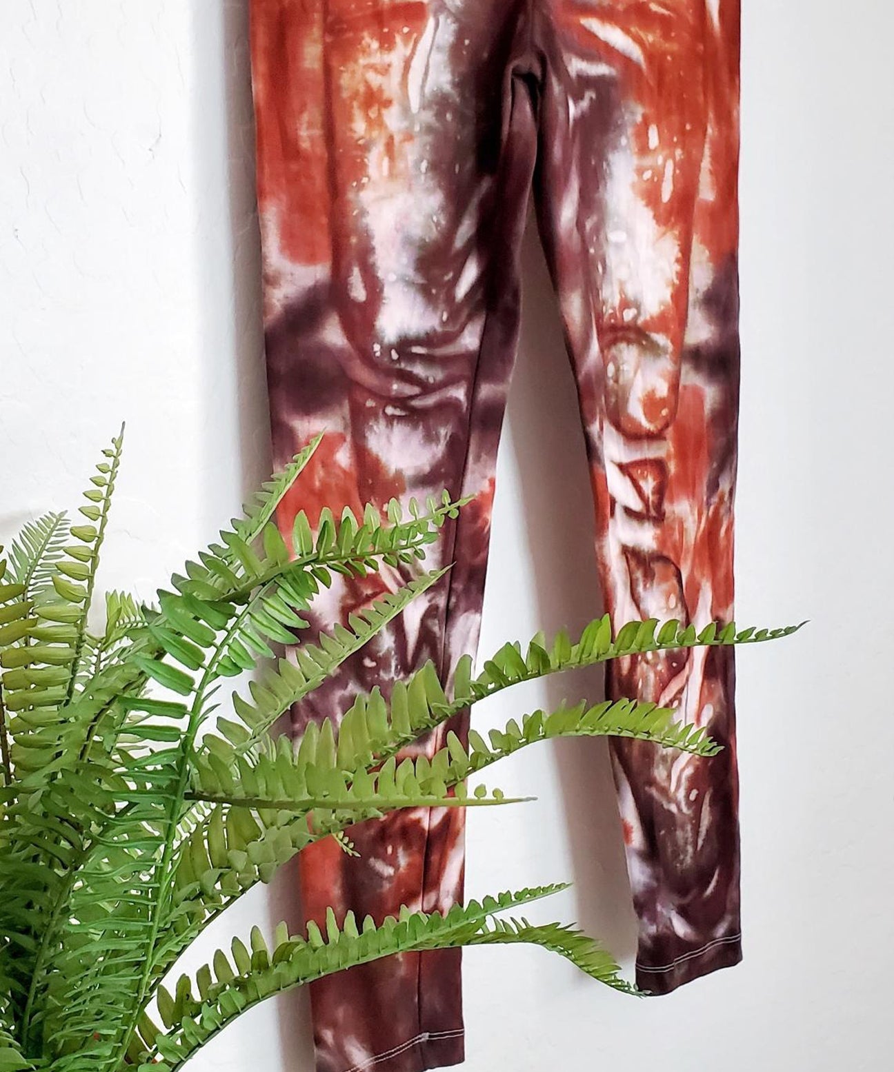 A burnt orange and brown tie dye pair of yoga leggings.