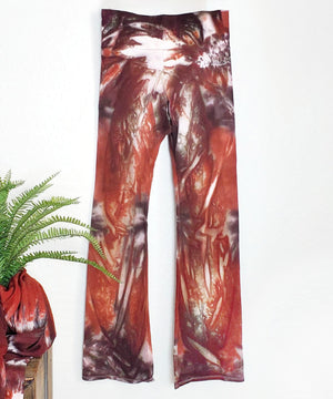 A rust and brown tie dye pair of yoga pants featuring a wide waistband.