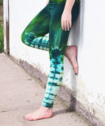 Woman wearing the Emerald Dragon tie dye leggings in green.