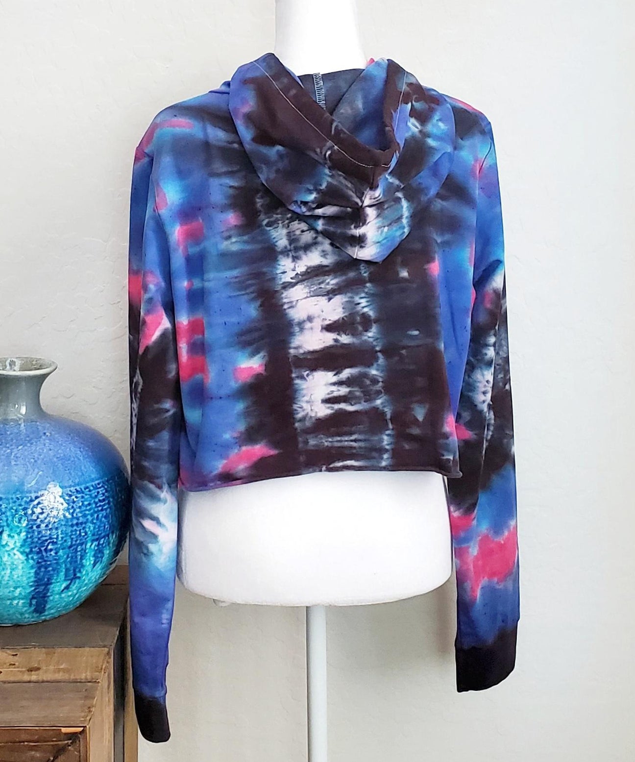 Blue, pink and black tie dye hoodie crop top with long sleeves and draw strings.