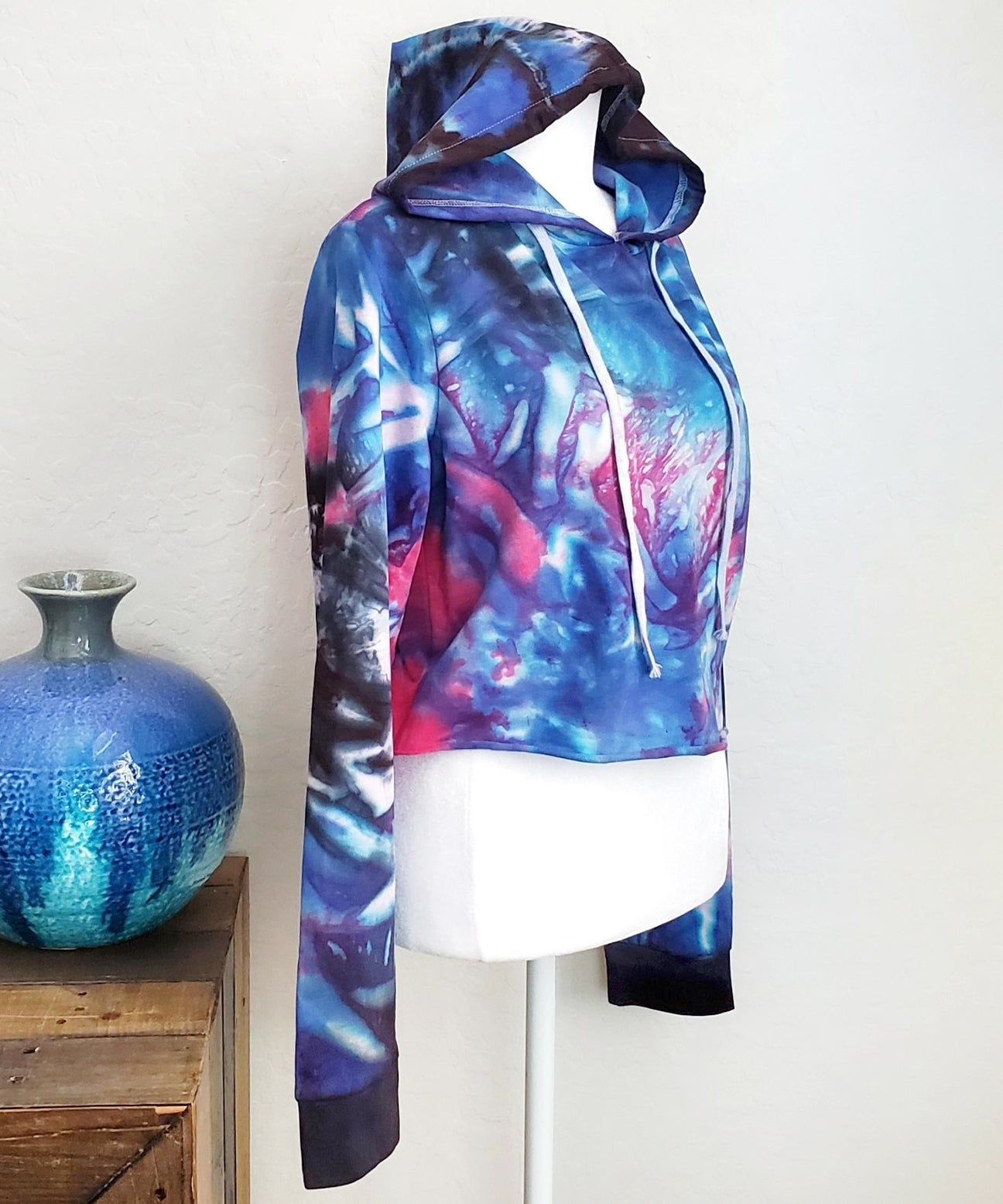 Blue, pink and black tie dye hoodie crop top with long sleeves and draw strings.