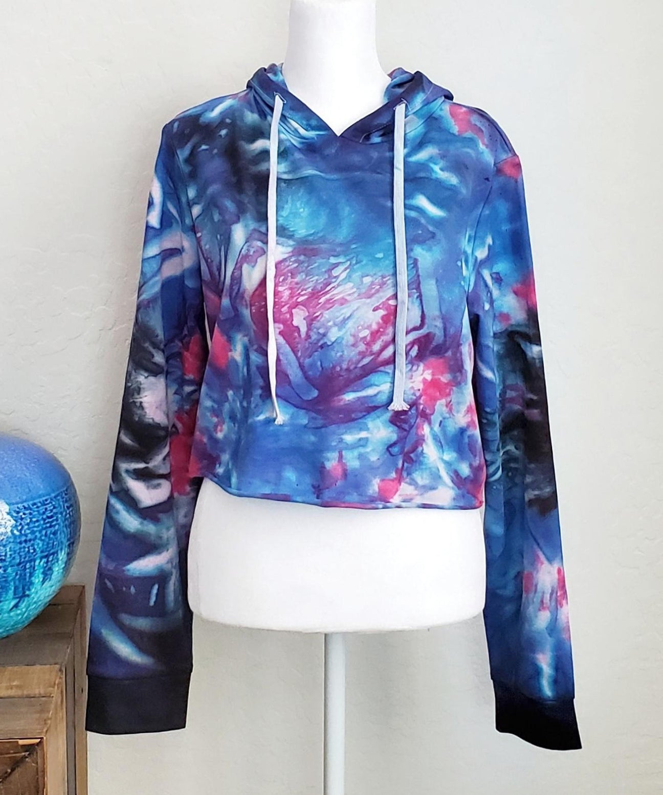 Blue, pink and black tie dye hoodie crop top with long sleeves and draw strings.