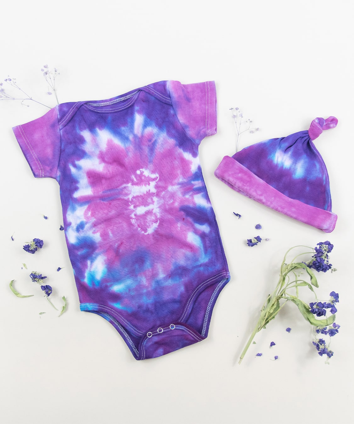 Purple and pink organic cotton tie dye bodysuit and baby hat set by Akasha Sun.