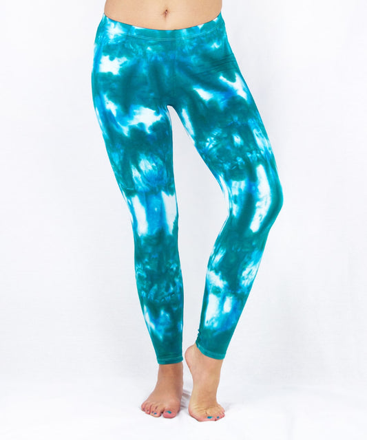 Woman wearing a pair of teal and white tie dye leggings by Akasha Sun.
