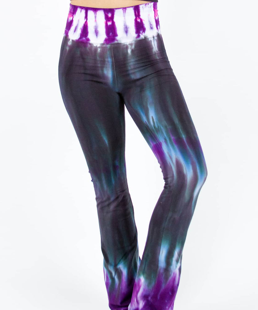 Woman wearing a pair of Akasha Sun sustainable cotton tie dye yoga pants in the colors black and purple.