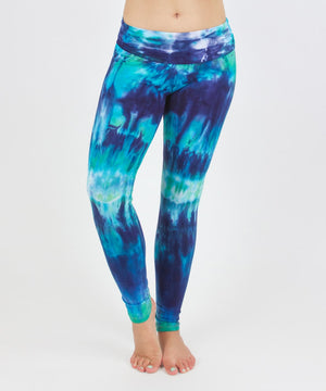 Woman wearing the Galapagos Islands tie dye fold over leggings that feature navy blue, teal, and aqua.