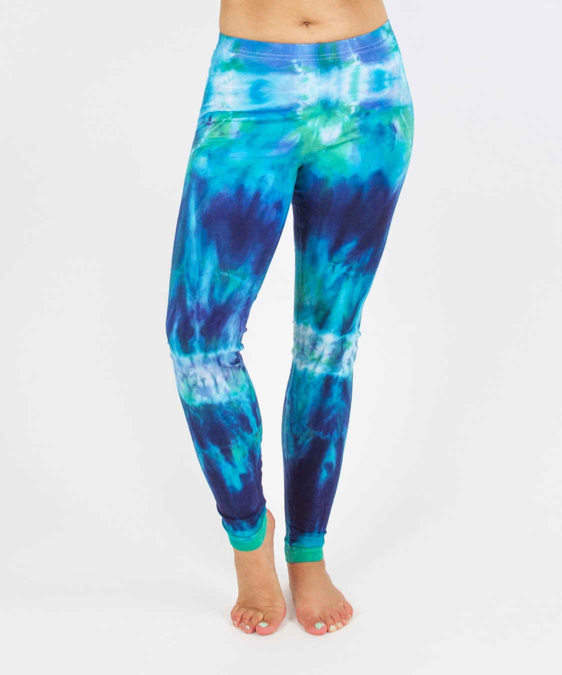 Woman wearing the Galapagos Islands tie dye leggings that feature the colors, navy blue, teal, and aqua.