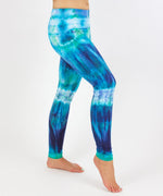 Woman wearing the Galapagos Islands tie dye leggings that feature the colors, navy blue, teal, and aqua.