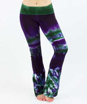 Woman wearing a pair of purple and green tie dye yoga pants with a fold over waistband by Akasha Sun.