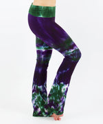 Woman wearing a pair of purple and green tie dye yoga pants with a fold over waistband by Akasha Sun.