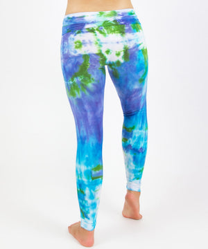 
                
                    Load image into Gallery viewer, Woman wearing the Grenada tie dye leggings that feature a fold over waistband.  The colors of the leggings include aqua, lavender, and emerald.
                
            
