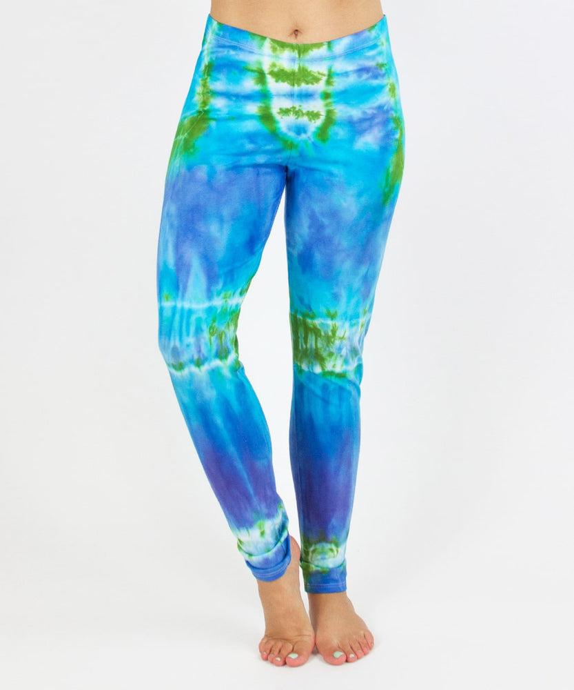 
                
                    Load image into Gallery viewer, Woman wearing the Grenada tie dye leggings that feature hues of aqua, lavender, and emerald.
                
            