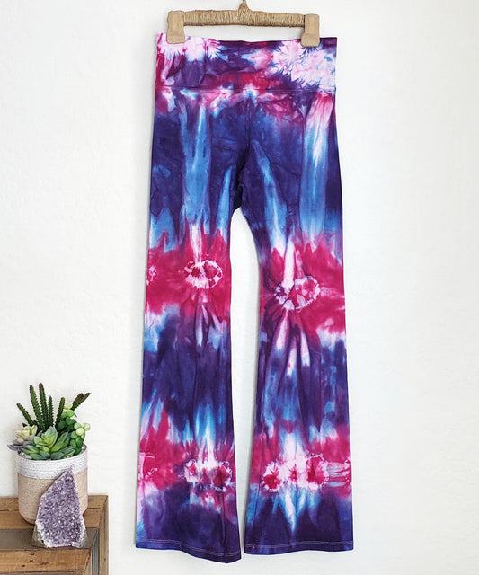 Purple and pink tie dye yoga pants with a wide waistband.